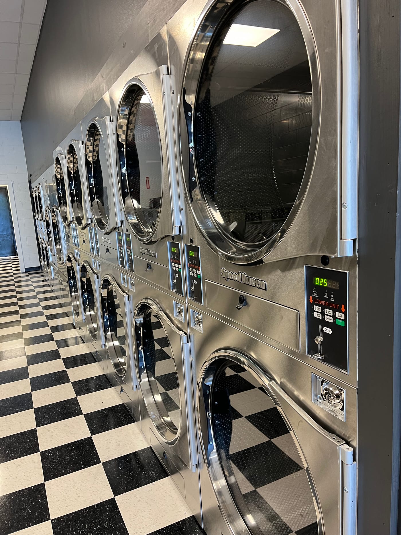 The bright row of Speed Queen stacked dryers inside The Laundry Room in Roxboro, NC