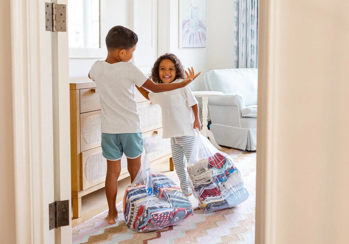 Two happy kids at home receiving their bags of freshly folded laundry, delivered to the door